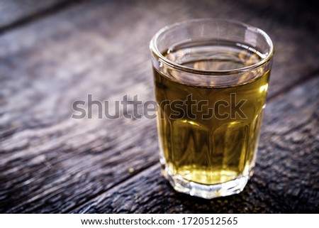 small glass cup for alcoholic drink. Rustic wood background.