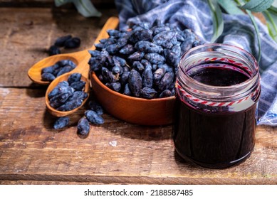 Small glass jar with homemade  haskap berry jam, on wooden background with bowl of fresh haskap (honeysuckle, honeyberry) berries, copy space - Shutterstock ID 2188587485