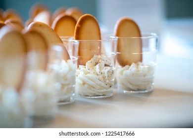 Small glasses with sample of cheesecake mousee and italian biscuits  at a tasting.