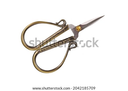 Small golden old fashioned sewing scissors isolated on white background