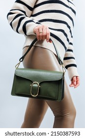 Small Green Leather Bag In A Female Hand On A White Background. Shoulder Bag. A Woman With A Green Handbag. Style, Fashion, Vintage And Elegance.