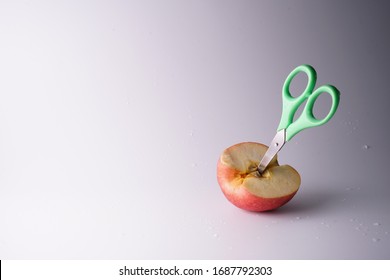 The Small Green Scissors Stab In The Half Of Red Fresh Apple.It Is A Super Cool Wallpaper.