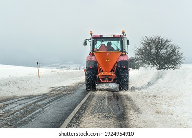 Small Gritter Maintenance Tractor Spreading De Icing Salt On Asphalt Road, View From Car Driving Behind