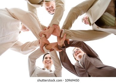 Small Group Of Business People Joining Hands, Low Angle View.