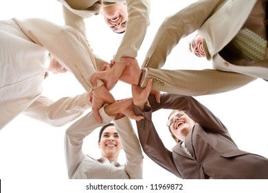 Small Group Of Business People Joining Hands, Low Angle View.