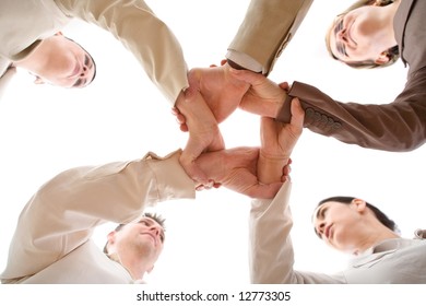 Small Group Of Business People Joining Hands, Low Angle View.