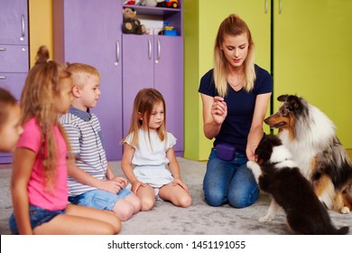 Small Group Of Children Playing With Therapy Dog In The Preschool 