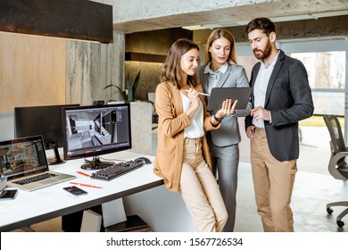 Small group of creative office employees working with digital tablet, standing together in the modern office of architectural firm - Powered by Shutterstock