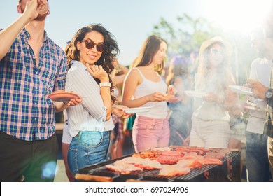     Small group of friends drinking alcohol and having a meal at barbecue party  - Shutterstock ID 697024906