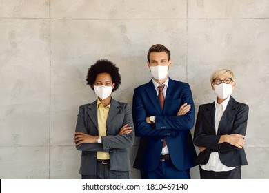 Small Group Of Happy Business People Feeling Confident While Standing  With Arms Crossed And Wearing Face Masks Due To COVID-19 Pandemic. Copy Space. 