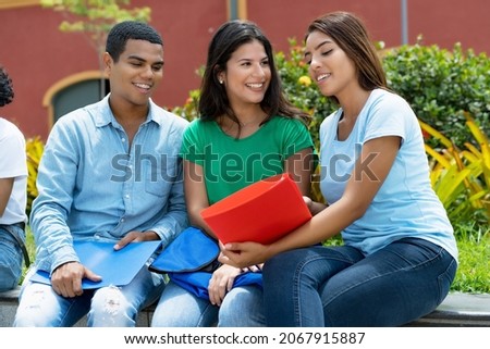 Small group of learning and talking muti ethnic students outdoor in summer