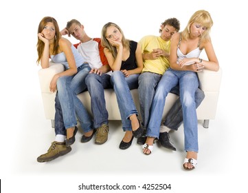 Small Group Of Sad Teenagers Sitting On Couch. One Girl Is Looking At Watch. White Background, Front View