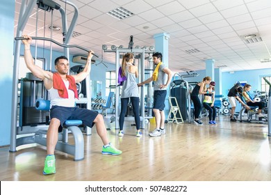 Small Group Of Sportive Friends At Gym Fitness Club Center - Happy Sporty People Interacting In Weight Room Training - Social Gathering Concept In Sport Lifestyle Context - Main Focus In Middle Frame