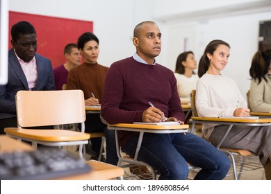 Small group of students attentively listening to lecture in classroom