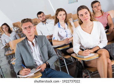 Small Group Of Students Attentively Listening To Lecture In Classroom..