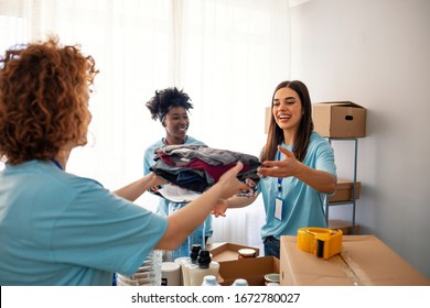 Small group of volonteers working on humanitarian aid project. Group of mixed race people working in charitable foundation. We love to help other people. Generous people helping to poor people - Shutterstock ID 1672780027