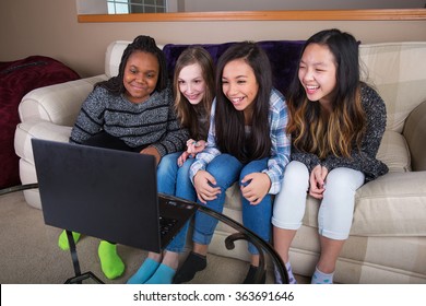 Small Group Of Young Girl Friends Watching Streaming Tv On Compu