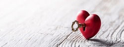Petit Coeur Rouge Taillé À La Main Avec Clé Dorée Sur Table En Bois Rustique - La Clé De Votre Concept Coeur