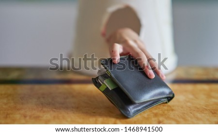 A small hand stealing a wallet.             