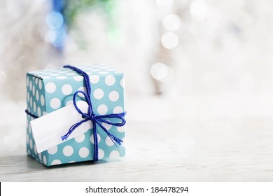 Small handmade gift box over shiny ornaments