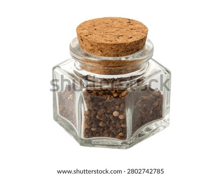 A small hexagonal glass spice pot filled with dark ground seasoning and whole coriander seeds, sealed tightly with a textured natural cork lid. This clear kitchen storage container from the file ultra-realistic-photo---hexagonal-glass-spice-pot-.jpg is shown at an angle, perfectly isolated on a transparent background for culinary and home design projects.