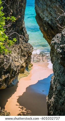 Small hidden Beach between Rockes covered by Cactus on Geger Beach in Nusa Dua Bali