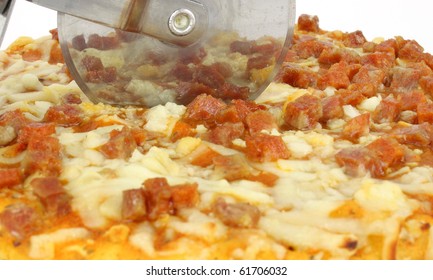 Small Home Cooked Pepperoni Pizza Being Cut.