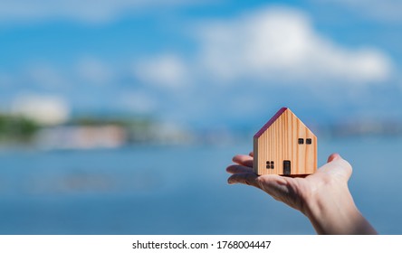 Small Home Model On Hand With Bokeh Background, Miniature House
