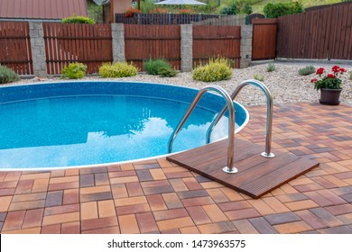 Small Home Swimming Pool With Two Black Sun Loungers