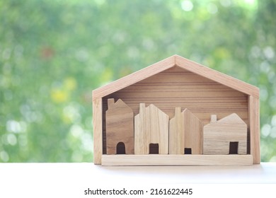 Small House In Big House On Natural Green Background, Business Investment And Real Estate Concept