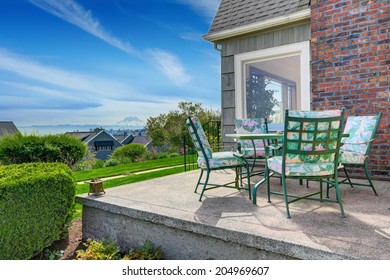 Small House With Brick Chimney. View Of Backyard Walkout Deck With Patio Table Set Overlooking Amazing Mountain Rainer