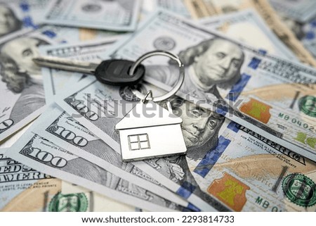 Small house model with keys on 100 new US dollars banknotes. Buy or rent. Mortgage concept