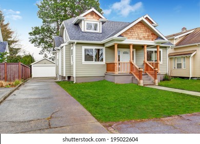 Small House With Wooden Column Porch. View Of Garage And Driveway