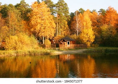 Small House And Wooden Pier At Sunrise In Autumn. Aerial View. Beautiful Landscape With House On  Island On The Lake, Colorful Trees.

