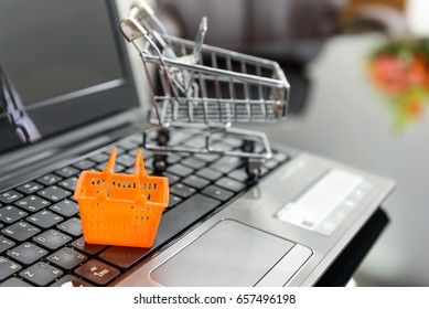 Small Housewife Shopping Basket On A White Smart Pad / Device And A Laptop. Concept Of Brick And Mortar Shop Will Eventually Be Replaced By A New Virtual Online Shopping Technology In Next Few Years.