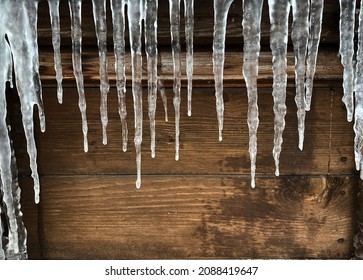 Small icicles on a wooden background. Template for an inscription. Mockup for design