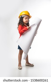 Small Indian Girl Engineer With Yellow Hard Hat And Drawing Paper Roll Or Plan, Isolated Over White Background