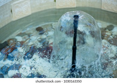 Small Indoor Fountain In A Pool With Decorative Stones, Pebbles And Rocks. Clean Water