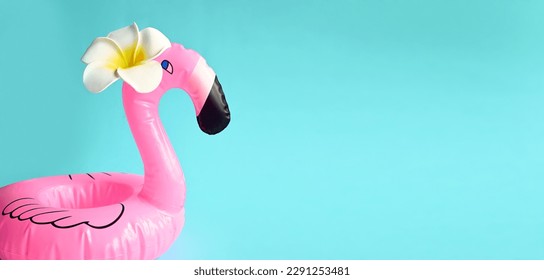 Small Inflatable flamingo and tropical flower on blue background