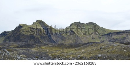 Small inselbergs covered with green grass in Hafursey, Iceland