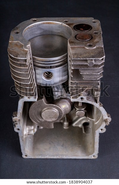 A small\
internal combustion engine shown in section. View of the piston and\
rings in the engine. Dark\
background.
