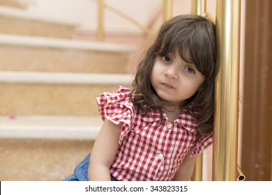 Small Iraqi Girl Sitting On Marble Stair Inside House 