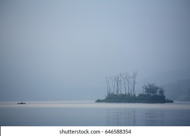 A Small Island With A Fishing Boat On The Lake In The Misty Morning