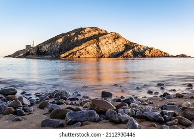Small island near Mumbles Head and Lighthouse at sunset, Gower Peninsula, South Wales, The United Kingdom