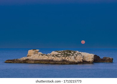 Small Island With Red Moon In Gargano Coast, Puglia, Italy