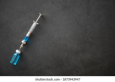 small jars with injection and syringe for injection on blue background near the chemical formula