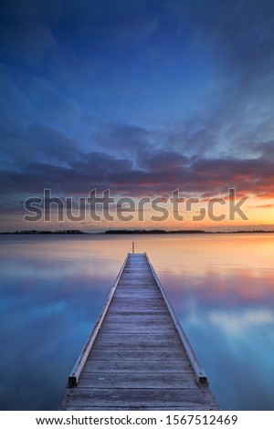 A small jetty on a lake at sunrise. Photographed near Amsterdam in The Netherlands.
