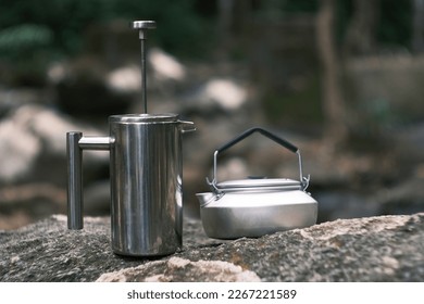 Small kettle and French press coffee maker on nature background. Outdoor recreation concept. Lapland. Vintage film grained filter with retro elements.  - Powered by Shutterstock