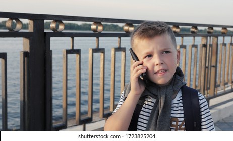 Small Kid Boy Walking Home With Backpack And Talking On The Phon