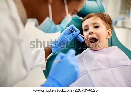 Small kid having his teeth examined by dentist at dental clinic.